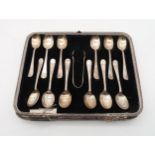 A cased set of George V Old English threaded pattern silver tea spoons and sugar tongs, by Barker