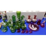 A collection of Mary Gregory green glass including jugs with stoppers, vases, a bowl and cranberry