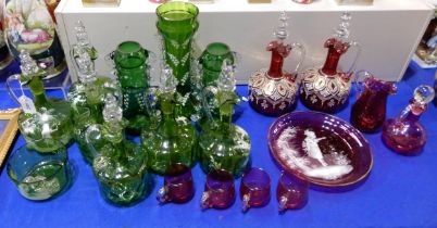 A collection of Mary Gregory green glass including jugs with stoppers, vases, a bowl and cranberry