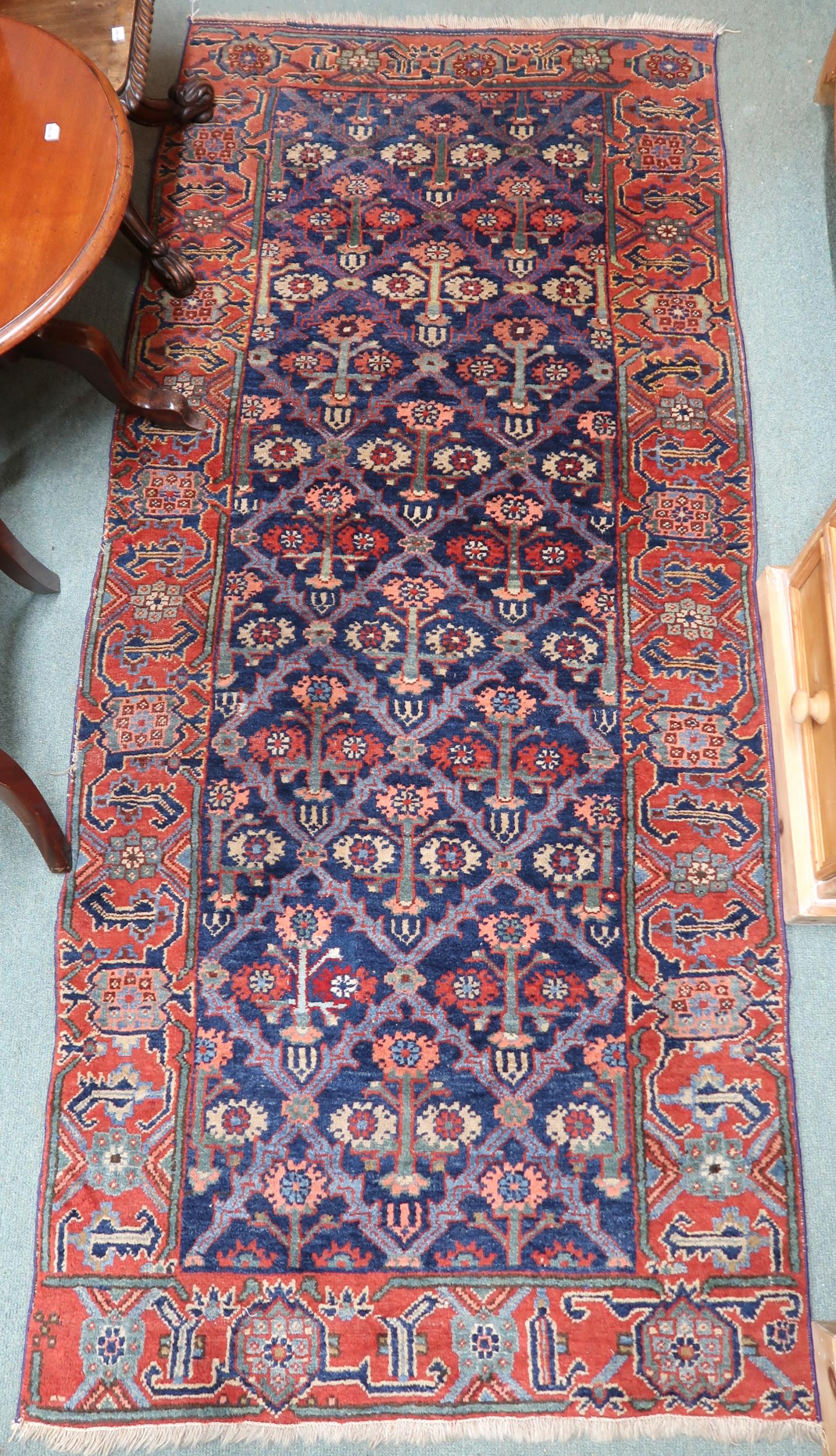 A blue ground Kurdish tribal runner with all-over floral pattern ground and pink geometric border,