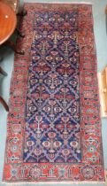 A blue ground Kurdish tribal runner with all-over floral pattern ground and pink geometric border,