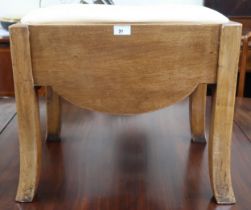 An early 20th century Art Deco style dressing stool with upholstered seat over shaped frieze sides