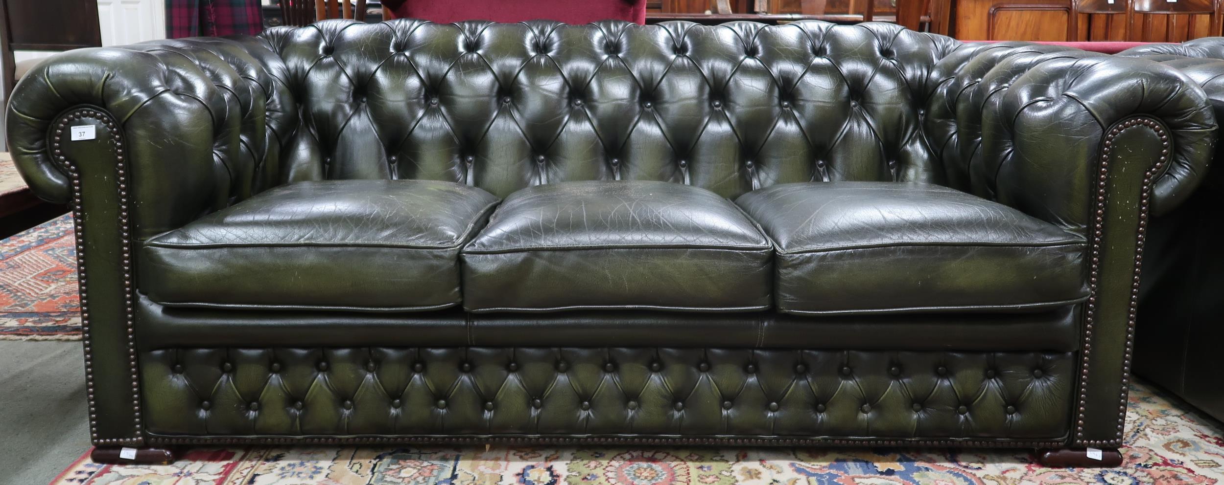 A 20th century forest green leather buttonback upholstered Chesterfield style three seater club