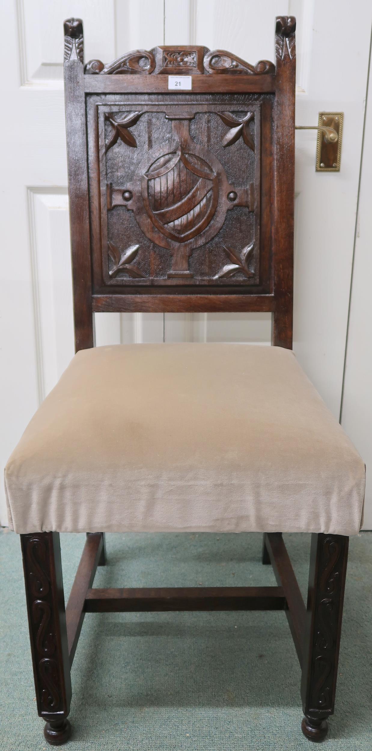 A 19th century oak hall chair with solid panel splat carved with shield over upholstered seat on