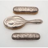 Two silver clothes brushes, decorated with Reynolds Angels, one by William Comyns, London, the other