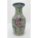 A CHINESE CELADON GROUND FAMILLE ROSE BALUSTER VASE decorated with dragons amongst clouds and