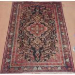 A BLACK FLORAL FOLIATE PATTERNED GROUND LILIHAN RUG  with red central medallion, matching
