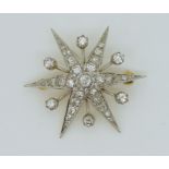 A DIAMOND STAR BROOCH mounted in 18ct yellow and white gold, set with estimated approx 1.12cts of
