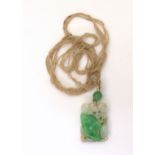 A CHINESE GREEN HARDSTONE PENDANT carved with foliage, with further hardstone bead (7.5mm) and glass