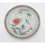 A CHINESE EXPORT FAMILLE VERTE DEEP DISH the well decorated with a bird amongst flowers,