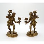 A PAIR OF GILT BRONZE FIGURAL CANDLESTICKS each modelled as a man, upon oval socle bases, 24.5cm