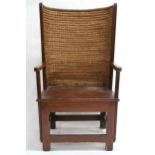 AN EARLY 20TH CENTURY STAINED BEECH ORKNEY CHAIR  with rush back rest over straight arms over