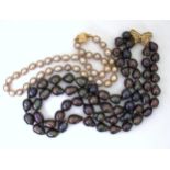 TWO GOOD STRINGS OF PEARLS a double string of black baroque pearls with a 9ct gold butterfly