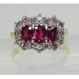 A RUBY AND DIAMOND RING set with three rubies, largest approx. 6mm x 3.7mm x 2.6mm, smaller