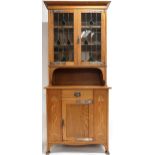 AN OAK ARTS & CRAFTS BOOKCASE  with moulded cornice over pair of leaded stained glass doors with