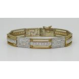 A 9CT GOLD KEY PATTERN BRACELET in yellow gold with the key patterns and bars set with sparkling
