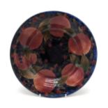 A MOORCROFT POMEGRANATE PATTERN DISH of shallow form, with green signature to base and impressed