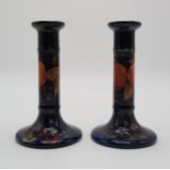 A PAIR OF MOORCROFT POMEGRANTE PATTERN CANDLESTICKS impressed marks and signed in blue to base