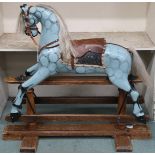 An early 20th century child's rocking horse with horse hair mane and tail, leather reigns and saddle