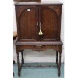 A 20th century mahogany cabinet on base with pair of panel cabinet doors over base with turned