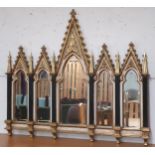 A 20th century gilt framed ecclesiastical style wall mirror with large shaped bevelled glass