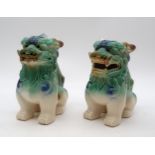 A pair of Chinese glazed stoneware Foo dogs, decorated in the Sancai palette, 17cm high (2)