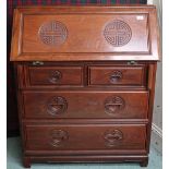 A 20th century Chinese hardwood writing bureau with fitted fall front writing compartment over two