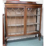 An early 20th century mahogany display cabinet with gadrooned top of pair of glazed doors on