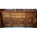 A late Victorian oak sideboard with two central drawers over pair of carved cabinet doors flanked by