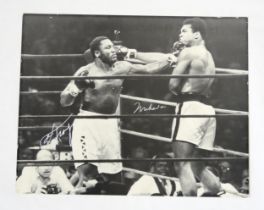 A large black and white photograph of Muhammad Ali and Joe Frazier signed by both boxers in silver