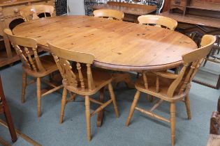 A 20th century pine extending dining table and six chairs, table oval extending top with single leaf