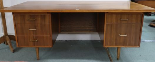 A mid 20th century teak desk with shaped rectangular top over to banks of drawers on tapering
