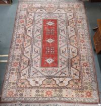 A beige ground Turkish rug with red central column within geometric patterned ground with