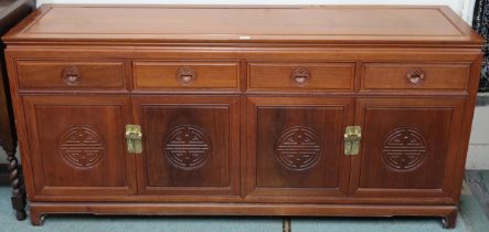 A 20th century Chinese hardwood sideboard with shaped rectangular top over four short drawers over