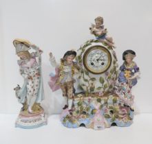 A continental ceramic clock with figures and a cherub, together with another figure of a man with
