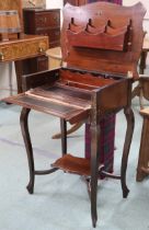 A late Victorian mahogany desk with shaped hinged top concealing fitted writing compartment over