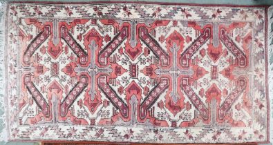 A cream ground Caucasian Chelebred rug with two pink crossed medallions and geometric borders, 186cm