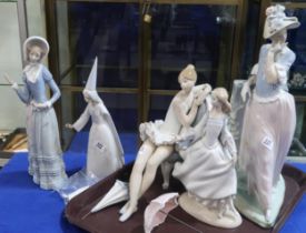 A group of Lladro figures including a sitting ballerina, a lady leaning on a wall with a parasol etc