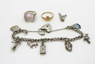 A 9ct gold Claddagh ring, size O1/2, and a silver charm bracelet with seven silver and white metal