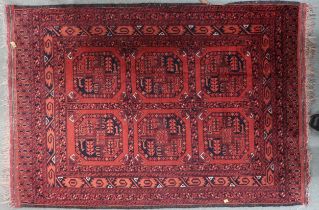 A red ground Bokhara rug with six geometric lozenges and multiple borders, 155cm long x 105cm