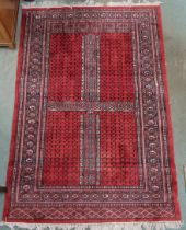 A red ground Turkaman rug with four panelled ground with multicoloured geometric border, 190cm