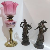 A Victorian oil lamp with cranberry glass shades and milk glass reservoir, together with a pair of