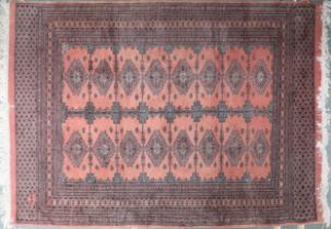 A pink ground Bokhara rug with lozenge patterned ground and multiple borders, signature to corner,