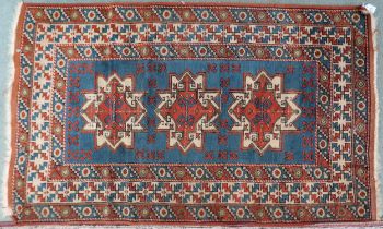 A blue ground Shirvan rug with three terracotta and cream medallions and multicoloured geometric