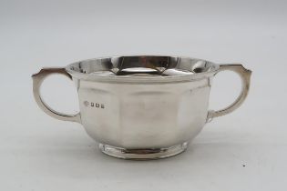 A George V silver twin-handled Christening cup, by Adie Brothers ltd, of faceted form, engraved to