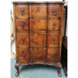 An early 20th century walnut veneered serpentine front four drawer chest on Queen Anne supports,