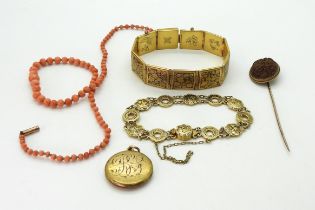 A yellow metal stick pin set with an oriental carved nut, weight 3.7gms, two damascene bracelets,