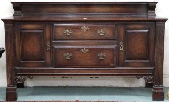 A 20th century stained oak sideboard with two central drawers flanked by cabinet doors, 111cm high x