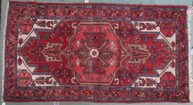A red ground Hamadan rug with geometric central medallion, cream spandrels and multicoloured