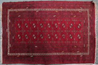 A red ground Bokhara rug with lozenge pattern ground with multiple borders, 157cm long x 104cm